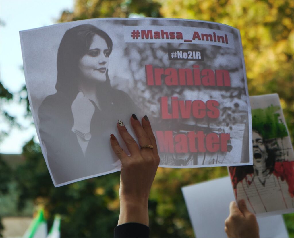 Image of a woman's hand holding a protest for Mahsa Amini Iranian Lives Matter